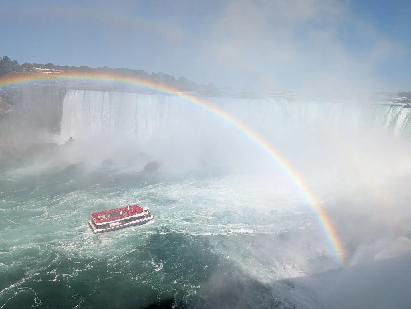 Un bateau dans la brume et un arc-en-ciel au pied des chutes canadiennes
